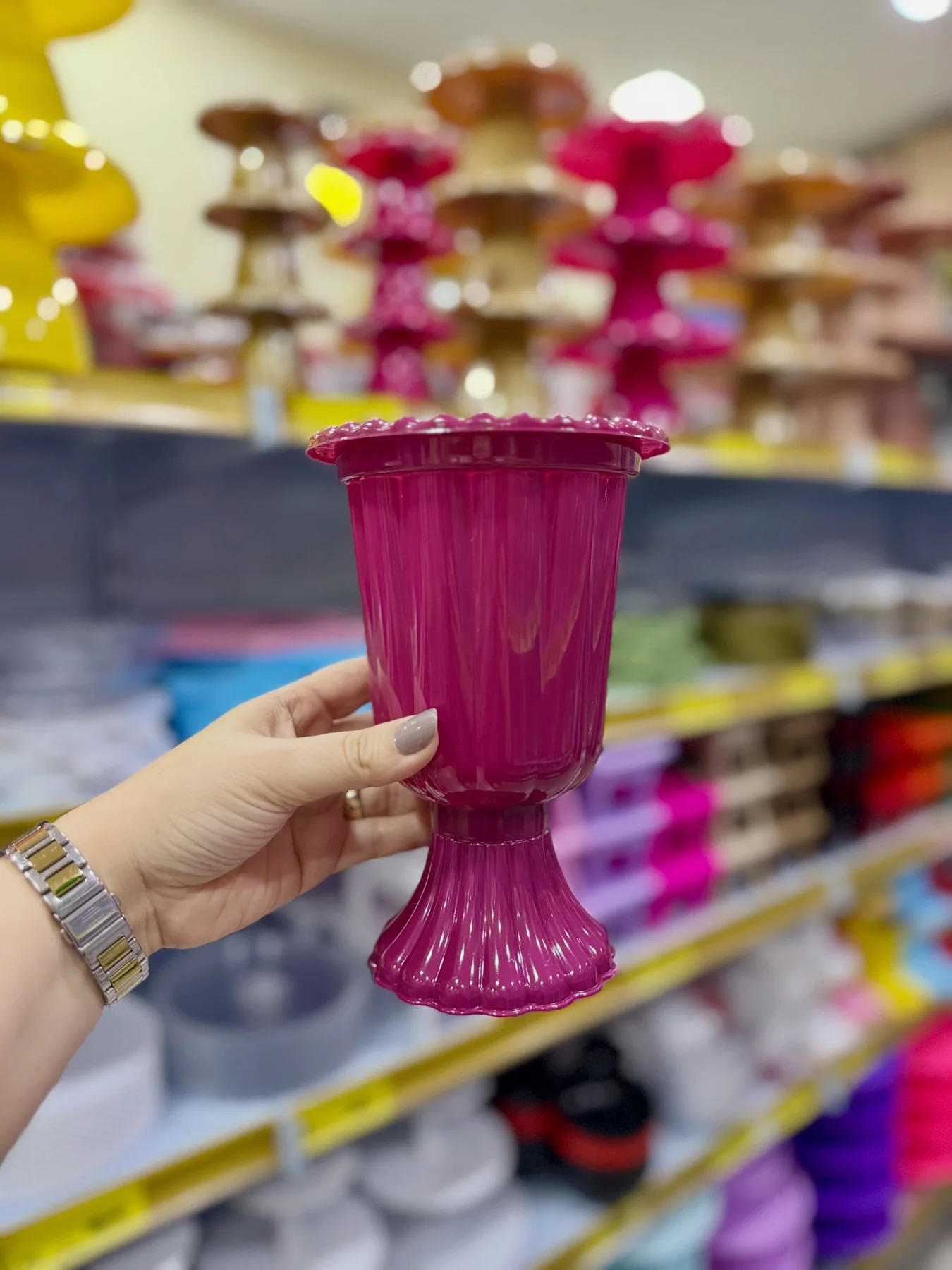 Vaso rosa fotografado diante das prateleiras da Karol Festa